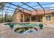 A screened-in pool and spa are surrounded by a brick patio, complemented by an outdoor bar and seating area at 1813 Glenbay Ct, Windermere, FL 34786