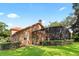 A shot of the back exterior featuring a screened patio and well-maintained lawn and garden at 1813 Glenbay Ct, Windermere, FL 34786