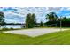 Exterior shot of a sand volleyball court near the lake with a net on a grassy area at 1813 Glenbay Ct, Windermere, FL 34786