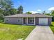 Charming single-story home with a well-manicured lawn, driveway, and attached one car garage, under a sunny sky at 1816 Alexander Ave, Sanford, FL 32771