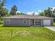 Charming single-story home featuring a well-maintained lawn and a one car garage, with mature trees in the background at 1816 Alexander Ave, Sanford, FL 32771