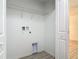 Clean, minimalist laundry room with hookups, shelving, and light vinyl floors at 1816 Alexander Ave, Sanford, FL 32771
