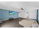 Open living room features sleek wood-look flooring, a modern ceiling fan, and a blue accent wall at 1905 Emily Blvd, Winter Haven, FL 33884