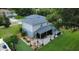 Aerial view of the home's backyard with a covered patio, landscaped garden, and a green lawn at 2032 Wavyleaf Ct, Apopka, FL 32712