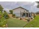 Well-maintained backyard with a grass area, beautiful planters, and seating under string lights at 2032 Wavyleaf Ct, Apopka, FL 32712