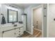 Well-lit bathroom with updated vanity, fixtures, wood-look floors and shower with tile surround at 2032 Wavyleaf Ct, Apopka, FL 32712