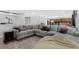 Open-concept living room with comfortable gray sectional sofa and wood-look floors at 2032 Wavyleaf Ct, Apopka, FL 32712