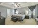 Spacious bedroom featuring a ceiling fan, tray ceiling, and an ensuite bathroom with a glass-enclosed shower at 2032 Wavyleaf Ct, Apopka, FL 32712