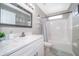 Modern bathroom featuring marble countertop, white vanity, tub and shower combo at 207 Langham Dr, Davenport, FL 33897
