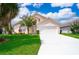Charming single Gathering home with a well maintained lawn, bright driveway, and lovely blue sky at 207 Langham Dr, Davenport, FL 33897