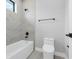 Modern bathroom with a soaking tub and commode, enhanced by tiled walls and matte black fixtures at 2300 S Brown Ave, Orlando, FL 32806