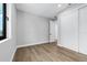 A view of a bedroom with light hardwood floors, closet with white sliding doors, and a bright window at 2300 S Brown Ave, Orlando, FL 32806