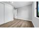 Empty bedroom with light hardwood floors, closet with white sliding doors, and a bright window at 2300 S Brown Ave, Orlando, FL 32806