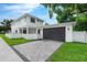 Spacious two-car garage featuring a paved driveway, set against a pristine white fence and lush lawn at 2300 S Brown Ave, Orlando, FL 32806