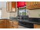 Close-up of a kitchen sink with dark countertops and wood cabinets at 2351 El Prado Ter, Deltona, FL 32725
