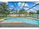 A screened-in pool with a blue and white tiled border sits under a bright blue sky at 2351 El Prado Ter, Deltona, FL 32725