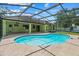 Beautiful pool and patio area with a screened enclosure, surrounded by lush landscaping at 2351 El Prado Ter, Deltona, FL 32725