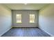 A bedroom with light gray walls, two windows, and laminate wood flooring at 2500 Sw 156Th Ln Rd, Ocala, FL 34473