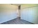 Bright bedroom featuring a closet with sliding doors and grey flooring; adjacent rooms visible through doorway at 2500 Sw 156Th Ln Rd, Ocala, FL 34473