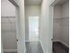 Bright hallway features gray wood-look floors and multiple storage closets, enhancing the home's functionality at 2500 Sw 156Th Ln Rd, Ocala, FL 34473