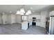Bright, open kitchen featuring white cabinets, island with sink, and modern stainless steel appliances at 2500 Sw 156Th Ln Rd, Ocala, FL 34473