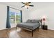 Light-filled bedroom with wood-look floors, ceiling fan, large window with curtains at 2513 Hickory Oak Blvd, Orlando, FL 32817