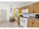 Bright kitchen with wood cabinets, white appliances, and a small dining table at 2513 Hickory Oak Blvd, Orlando, FL 32817