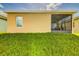 View of a home's backyard featuring a screened-in patio and lush green lawn at 2932 Whispering Trails Dr, Winter Haven, FL 33884