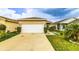 The property offers a spacious two-car garage with a wide driveway and well-maintained lawn at 2932 Whispering Trails Dr, Winter Haven, FL 33884