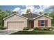 Inviting one-story home featuring a neutral color scheme, two-car garage, and stone accents at 317 Cornerstone Dr, Groveland, FL 34736
