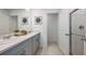 Elegant bathroom with double sinks, modern gray cabinetry, and a glass-enclosed shower at 325 Cornerstone Dr, Groveland, FL 34736