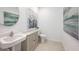 Contemporary half bathroom featuring a pedestal sink, modern fixtures, and decorative artwork at 325 Cornerstone Dr, Groveland, FL 34736