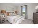 Cozy bedroom with plush carpeting, neutral tones, and a large window overlooking green space at 325 Cornerstone Dr, Groveland, FL 34736