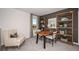 Well-lit home office space with a wooden desk, open shelving, and comfortable accent chair at 325 Cornerstone Dr, Groveland, FL 34736