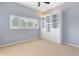 Bedroom featuring neutral carpet, plantation shutters on the windows, and built in bookshelves at 3604 Shell Cove Ln, Orlando, FL 32817