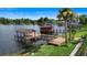 Beautiful lake view showcasing two story dock with wooden walkway and green lawn at 3604 Shell Cove Ln, Orlando, FL 32817