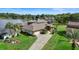 Expansive lakefront home with manicured lawn, mature palms, and a long driveway leading to an attached garage at 3604 Shell Cove Ln, Orlando, FL 32817