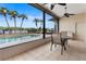 Covered lanai overlooking the pool with views of the lake and palm trees at 3604 Shell Cove Ln, Orlando, FL 32817