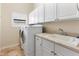 Functional laundry room featuring a washer, dryer, sink, and ample storage space at 3604 Shell Cove Ln, Orlando, FL 32817