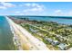 Scenic aerial shot featuring coastal homes adjacent to a sandy beach and ocean with cityscape in the distance on a sunny day at 4 Oceans West Blvd # 502D, Daytona Beach Shores, FL 32118