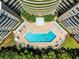 Stunning aerial view of the geometric pool design nestled between residential towers and lush greenery, perfect for summer relaxation at 4 Oceans West Blvd # 502D, Daytona Beach Shores, FL 32118