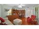 Comfortable home office with hardwood floors, built-in shelving, and a cozy red chair at 4 Oceans West Blvd # 502D, Daytona Beach Shores, FL 32118