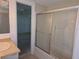 Bathroom with tiled shower behind sliding glass doors, adjacent to bedroom at 4415 Raymar Dr, Orlando, FL 32839