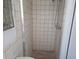 Full bathroom with tiled shower, white tiled walls and built in shelves at 4415 Raymar Dr, Orlando, FL 32839