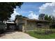 Home exterior featuring a stone wall, garage, and covered area at 4415 Raymar Dr, Orlando, FL 32839