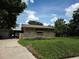 Home exterior featuring a stone wall, garage, and covered area at 4415 Raymar Dr, Orlando, FL 32839
