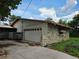 Exterior of garage with stone facade and adjacent covered area at 4415 Raymar Dr, Orlando, FL 32839