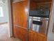 Kitchen boasting a stainless steel oven and retro wood panel refrigerator at 4415 Raymar Dr, Orlando, FL 32839