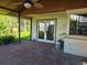 Covered brick patio with ceiling fan, and double doors leading to outdoor view at 4415 Raymar Dr, Orlando, FL 32839