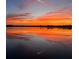Scenic sunset over a calm lake with vibrant orange and red hues reflecting on the water at 4415 Raymar Dr, Orlando, FL 32839
